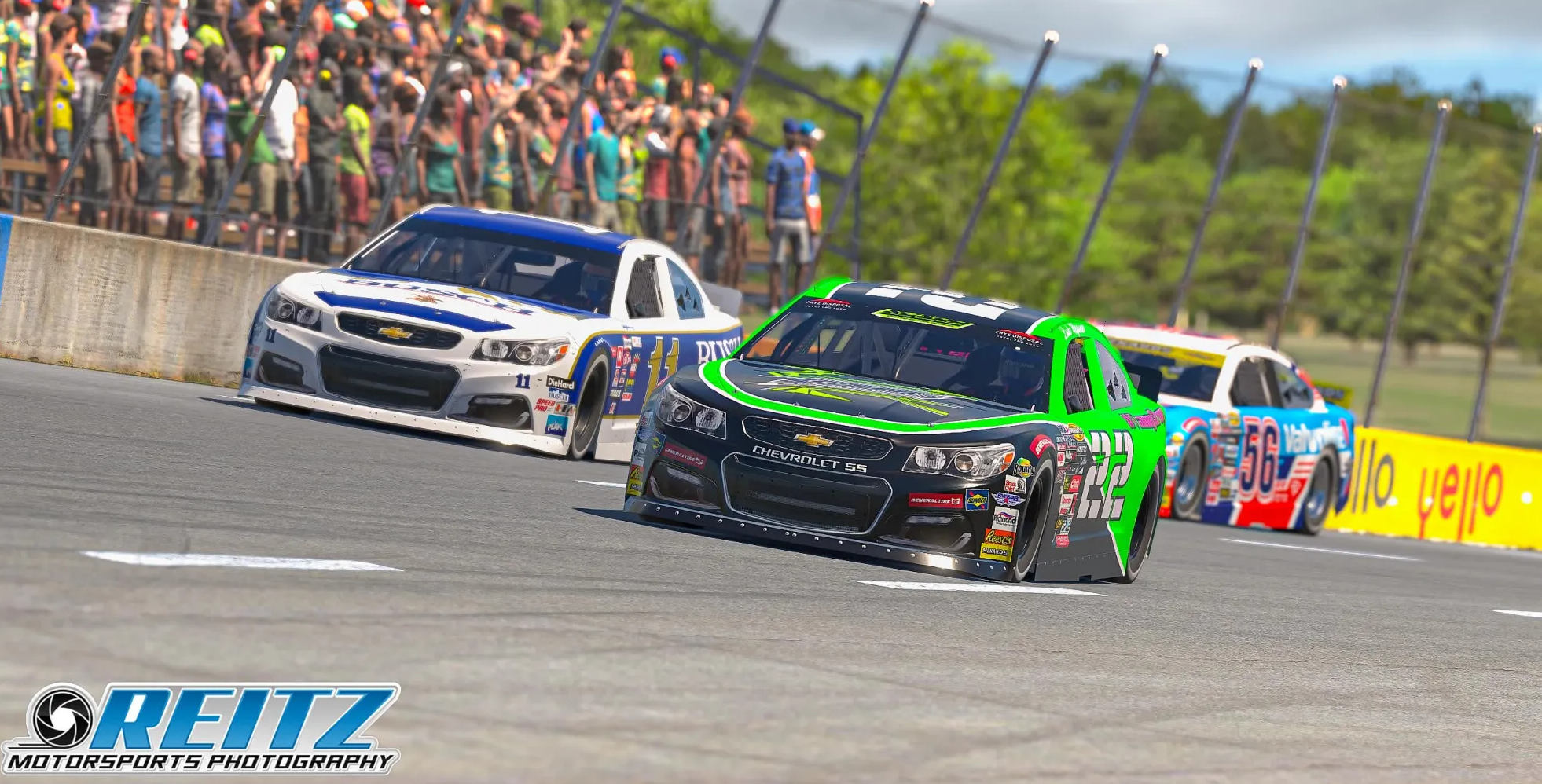 Three stock cars battling through a short-track corner